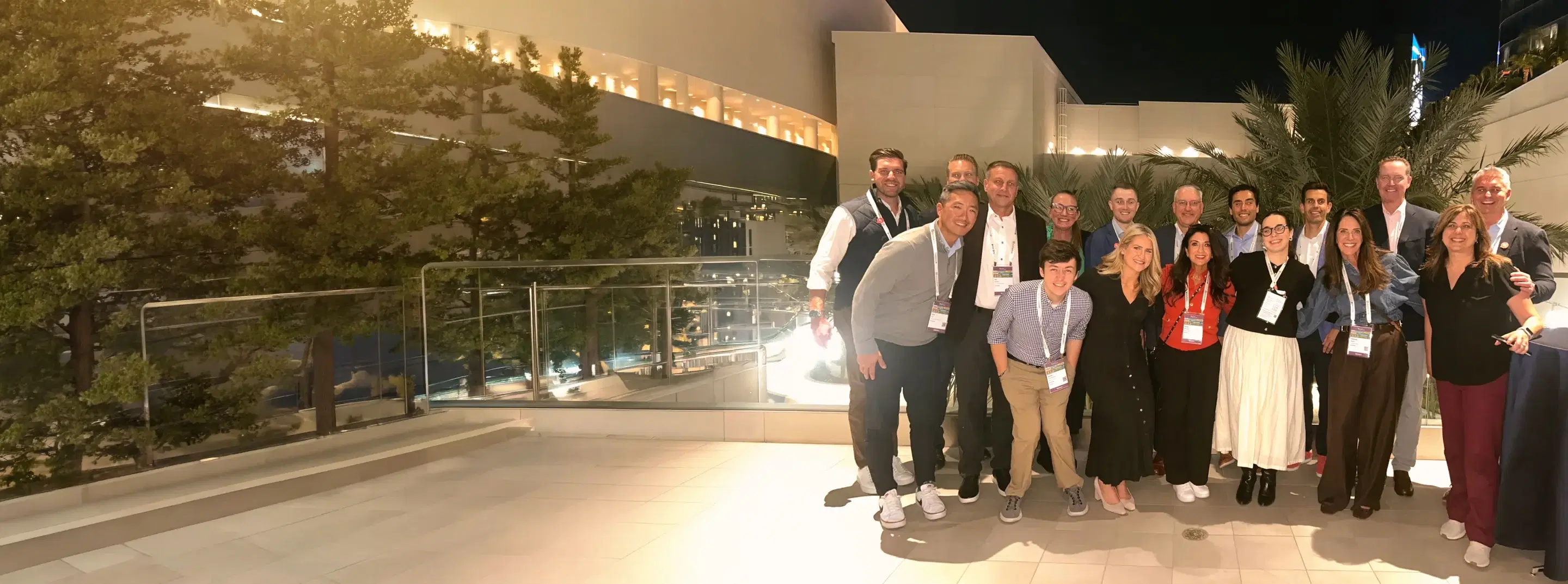 The Hi Marley team posing together on an outdoor terrace in the evening at a company event.